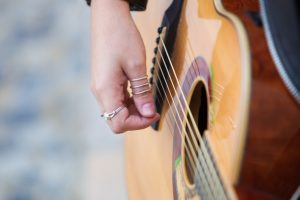 Κιθάρα και γυναικείο χέρι με πολλά δαχτυλίδια